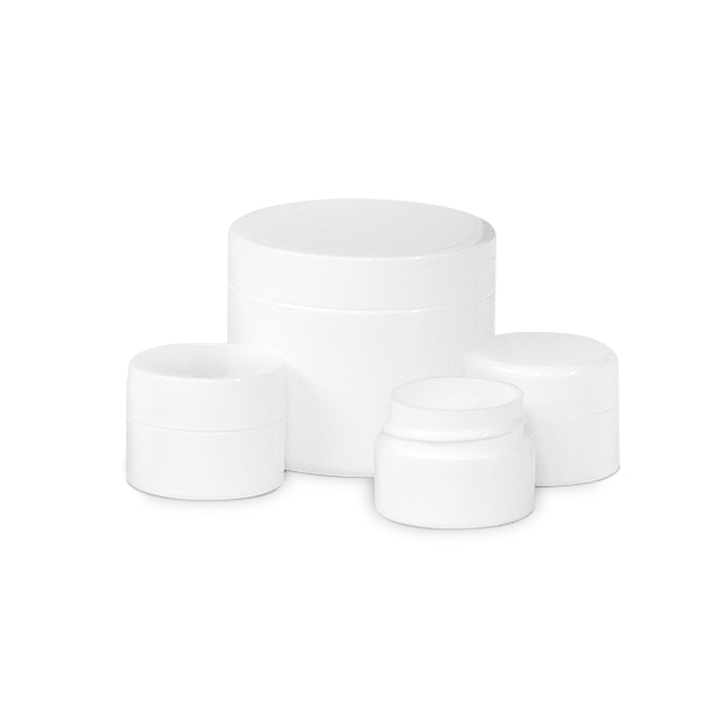 Four plain, white cosmetic jars of different sizes are arranged together on a white background. The jars are simple and cylindrical, with smooth, rounded lids.