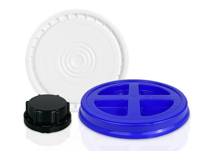 Three different plastic lids are displayed: a large white circular lid, a blue lid with four sections, and a smaller black screw-on cap, all against a white background.