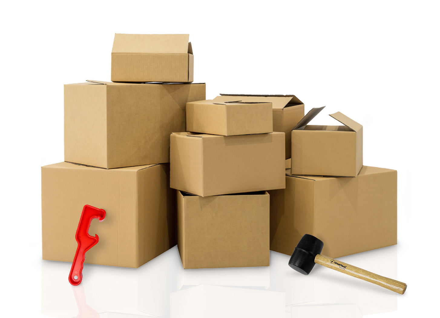 A group of various-sized cardboard boxes, some open and some closed, stacked together. In front are a red box cutter tool and a black rubber mallet. The background is white.