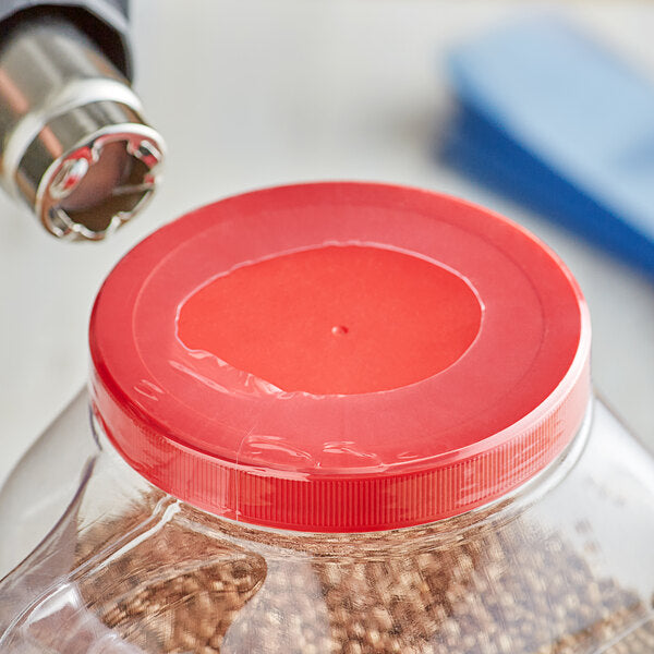 A Perforated Shrink Band (205mm x 28mm) for L410 lids is heat-sealed onto a container, creating a secure seal on the red plastic lid. Case contains 1,000 bands.
