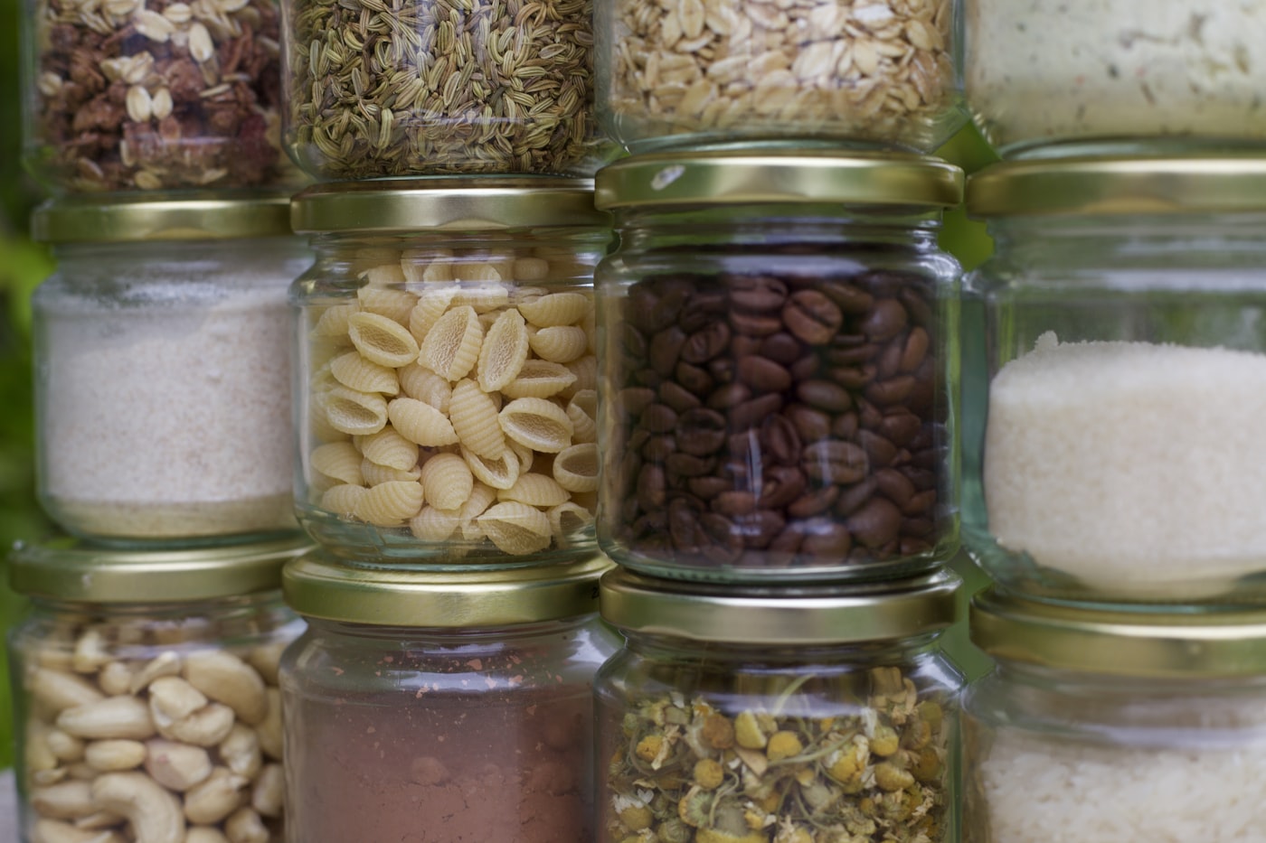 Organized pantry with glass jars filled with rice, pasta, beans, coffee, oats, and other dry goods for long-term food storage