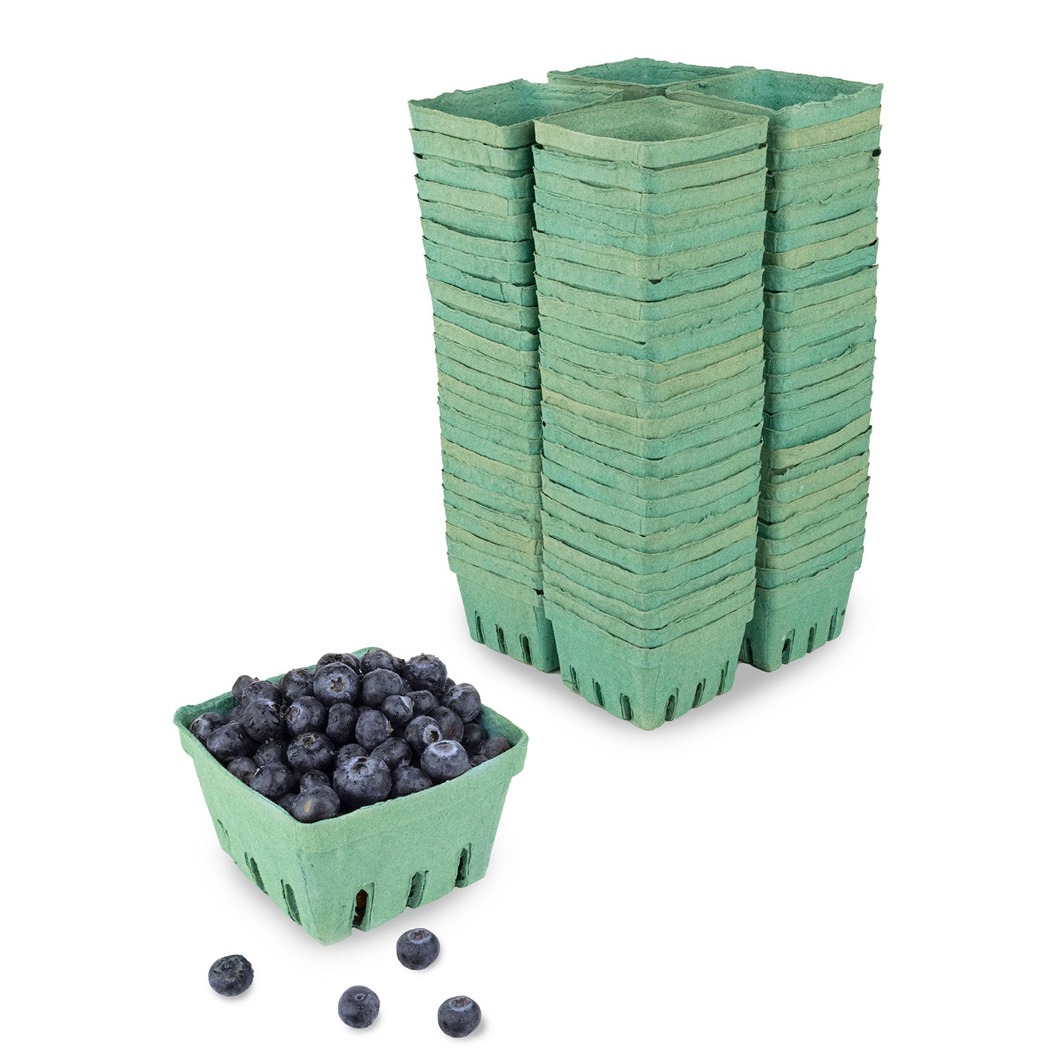 A stack of green cardboard berry baskets and one filled with blueberries, with a few loose blueberries in front of the basket.